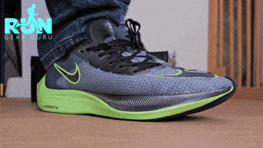 A GIF of man who's walking with a green and blue shoes on a wooden floor
