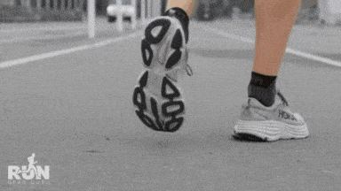 A GIF of a man running on road wearing hoka shoes
