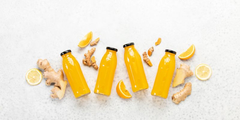 Bottles of ginger-turmeric juice with ingredients 