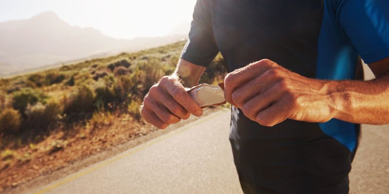 A jogger pauses to check his fitness tracker in a desert setting.